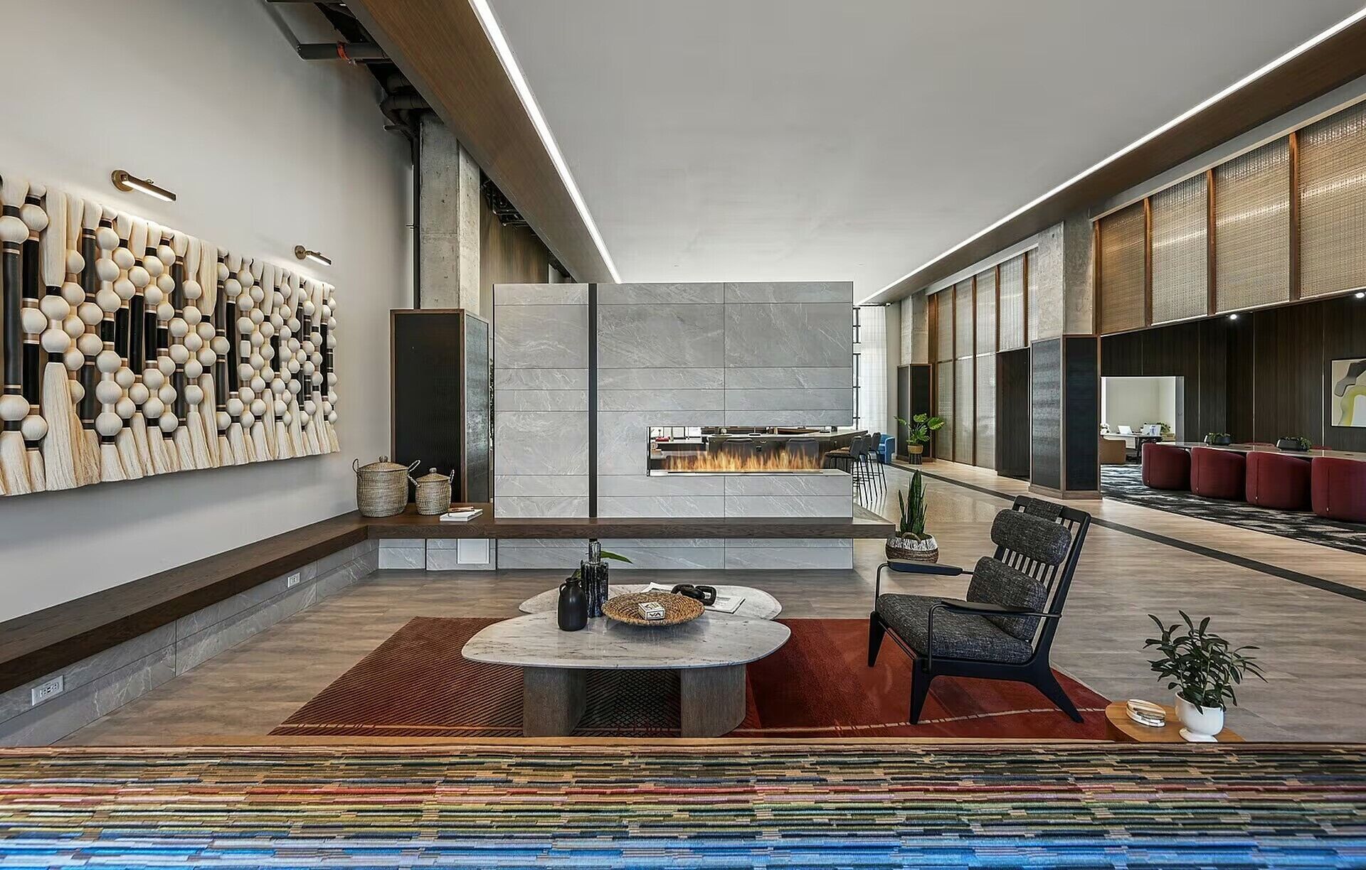 A modern interior with a fireplace, seating area, and a wall with a unique design.