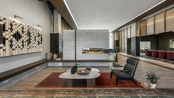 A modern interior with a fireplace, seating area, and a wall with a unique design.