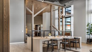 Un espacio de oficina moderno con una mesa grande, cuatro sillas y una planta en maceta.