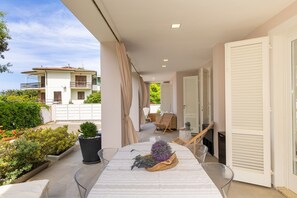 A balcony with a table, chairs, and potted plants. - Apartment 'Villa Atusca' with Private Garden, Wi-Fi and Air Conditioning (Castiglioncello)