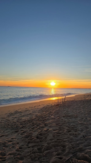 A beach with a sunset, sandy shore, and a ship in the distance. - Village house with pool, separate apartment & mountain views (Querença)