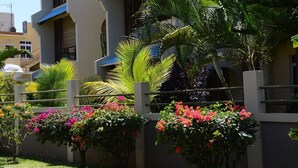 Ein Hotel mit modernem Design, das einen Balkon mit üppiger Bepflanzung und farbenprächtigen Blumen zeigt.
