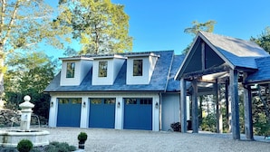 A two-story house with a covered garage and a fountain in the driveway. - Luxury Mountain Retreat with Scenic Balcony Views (Cashiers)