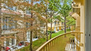Un balcón con vista a una zona residencial, que incluye casas y árboles.