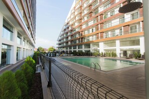 Ein modernes Hotel mit Schwimmbad, mehreren Etagen und einem gepflegten Außenbereich.