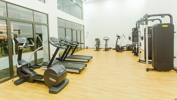 Ein Fitnessstudio mit Laufbändern, Crosstrainern und Gewichtsmaschinen.