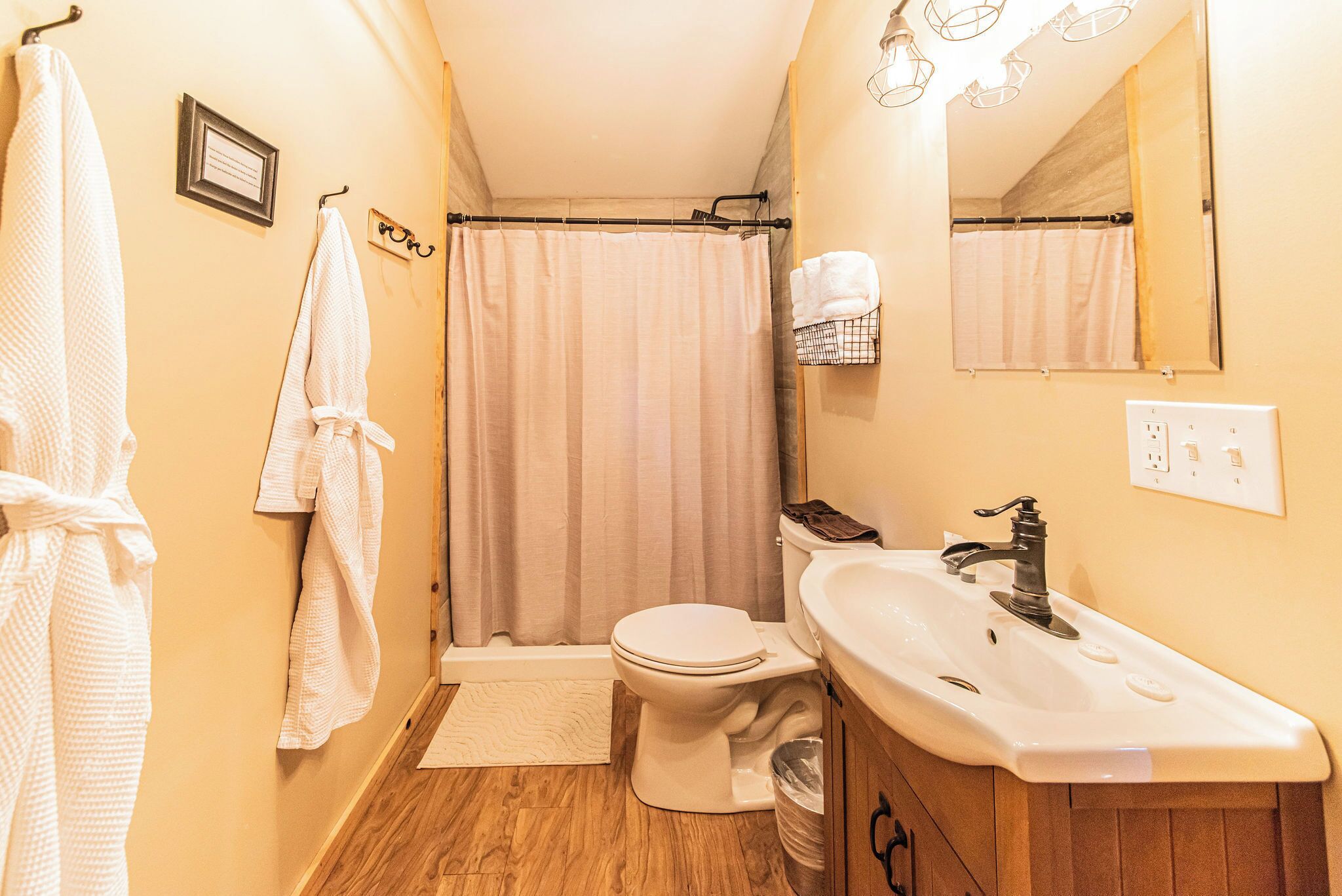 A bathroom with a toilet, sink, and shower curtain.
