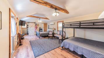 A rustic bedroom with a bunk bed, a desk, and a chair.
