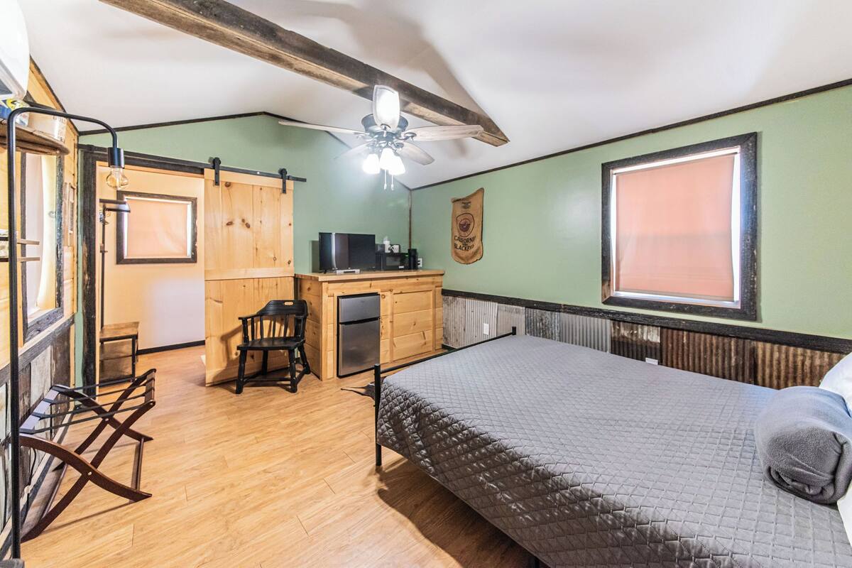 A room with a bed, a desk, a chair, and a window.