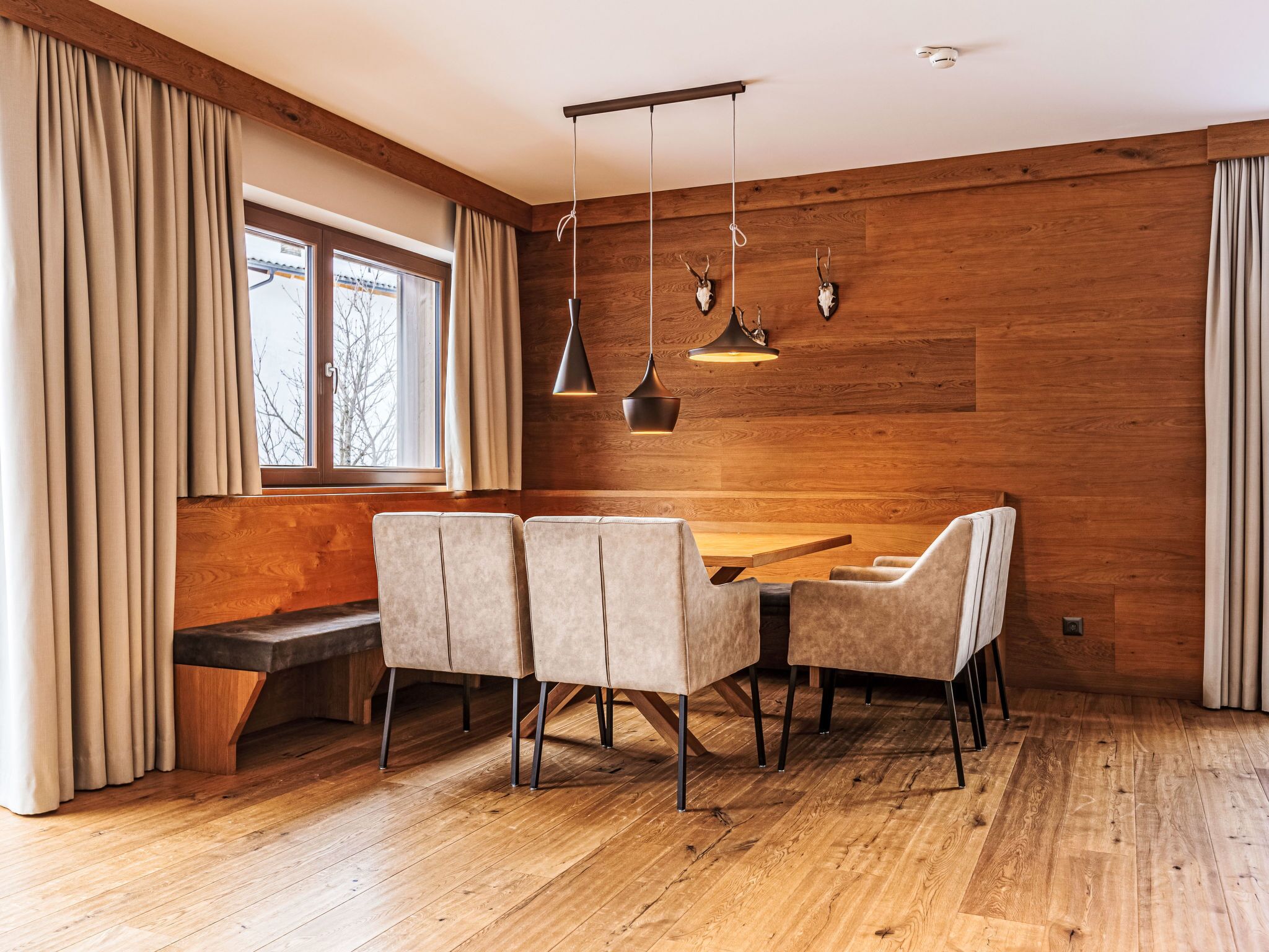 Ein stilvoller Essbereich mit einer Holzbänkl, einem Tisch und vier Stühlen.