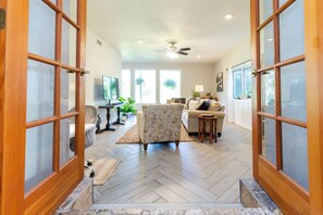 A spacious living room with a herringbone floor, a sofa, a coffee table, and a television. - Awesome 6-bedroom estate with AC in charming Savannah (Savannah)