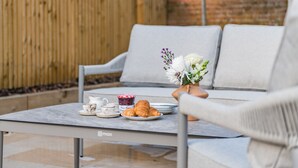 A table with a vase of flowers, croissants, and a cup of coffee in a casual outdoor setting. - Penshurst House Deal, Kent (Deal)