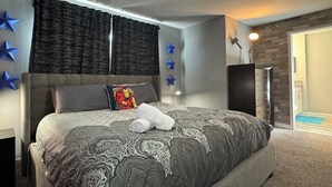 Un dormitorio con una cama grande, cortinas oscuras, una decoración de estrellas en la pared y un panel de pared de madera.