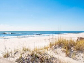 Ein Strand mit Dünen und einem Holzzaun.