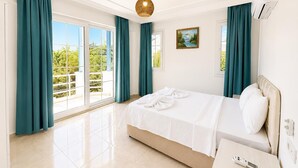 Ein Hotelzimmer mit Bett, Nachttisch, Fernbedienung und Blick auf Grün.