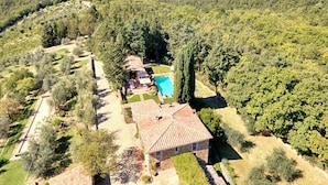 Une villa dotée d’une piscine, entourée d’une végétation luxuriante et de vignobles.