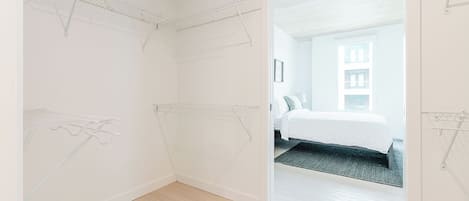 Una habitación con una cama, una puerta que da a otra estancia y un techo con estructura de cuadrícula.