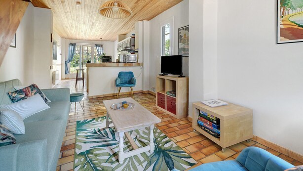 Een woonkamer met een bank, een salontafel, een televisie en een boekenkast.
