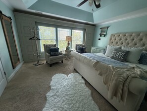 A bedroom with a large bed, a chair, a small table, and a window. - 3 Beds, 2.5 Baths+Fenced Yard for Family & Pets (Port Wentworth)
