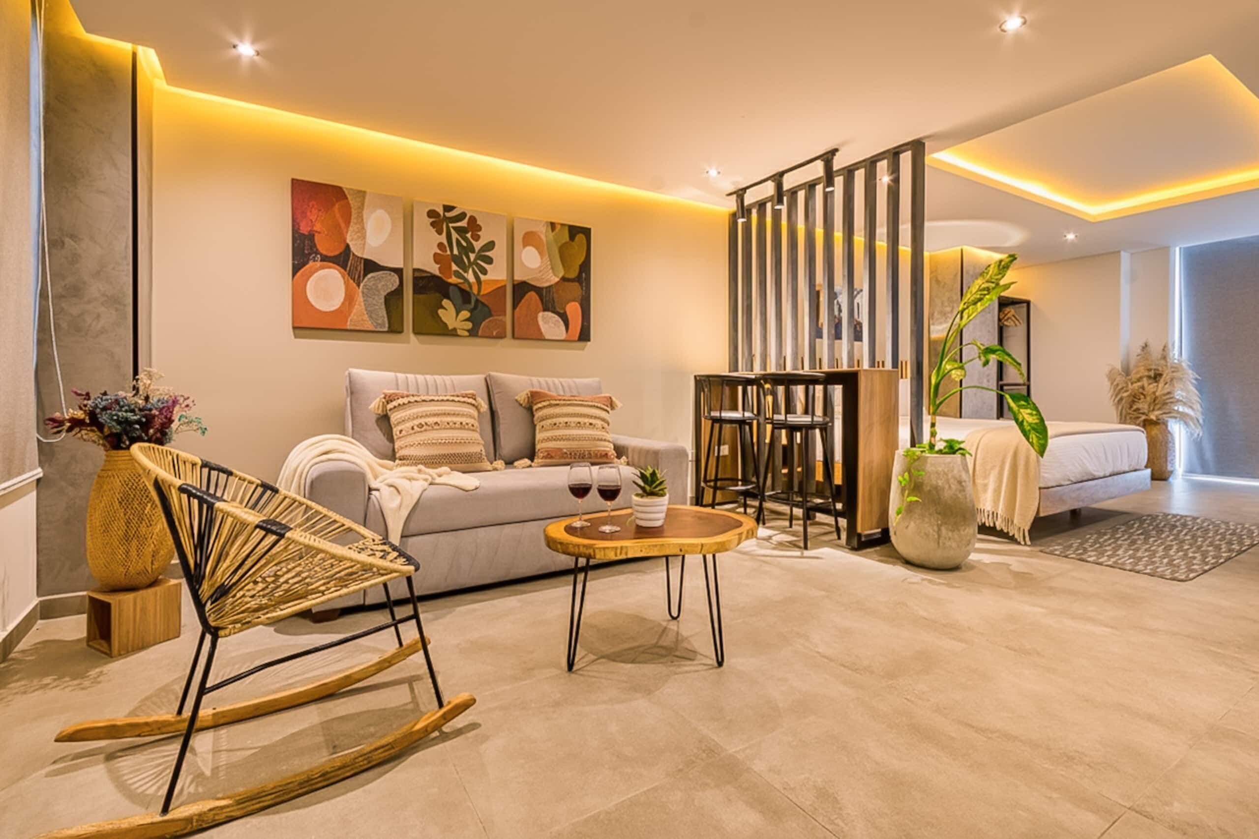 Una sala de estar moderna con un sofá, un sillón mecedora, una mesa de centro y una pared decorativa con arte abstracto.