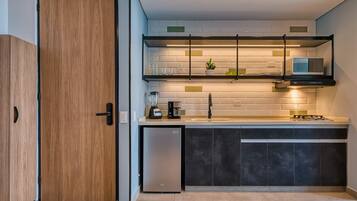 A modern kitchen with a built-in dishwasher, a microwave, and a coffee machine.