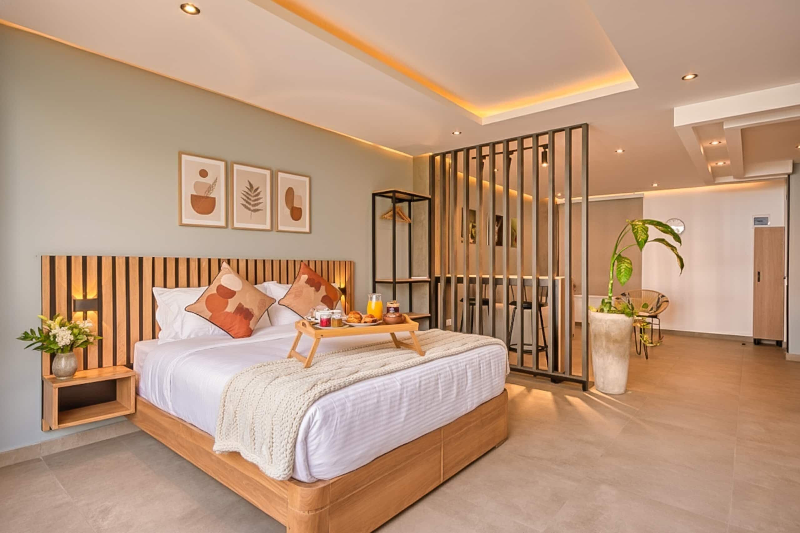 Un dormitorio moderno con una cama de madera, una bandeja para el desayuno y una planta grande en maceta.
