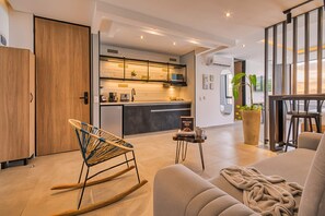 A modern living room with a sofa, a rocking chair, and a coffee table. - Amaris del Lili (Cali)