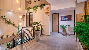 A modern interior with a staircase, potted plants, and a door marked with the number 405. - Amaris del Lili (Cali)