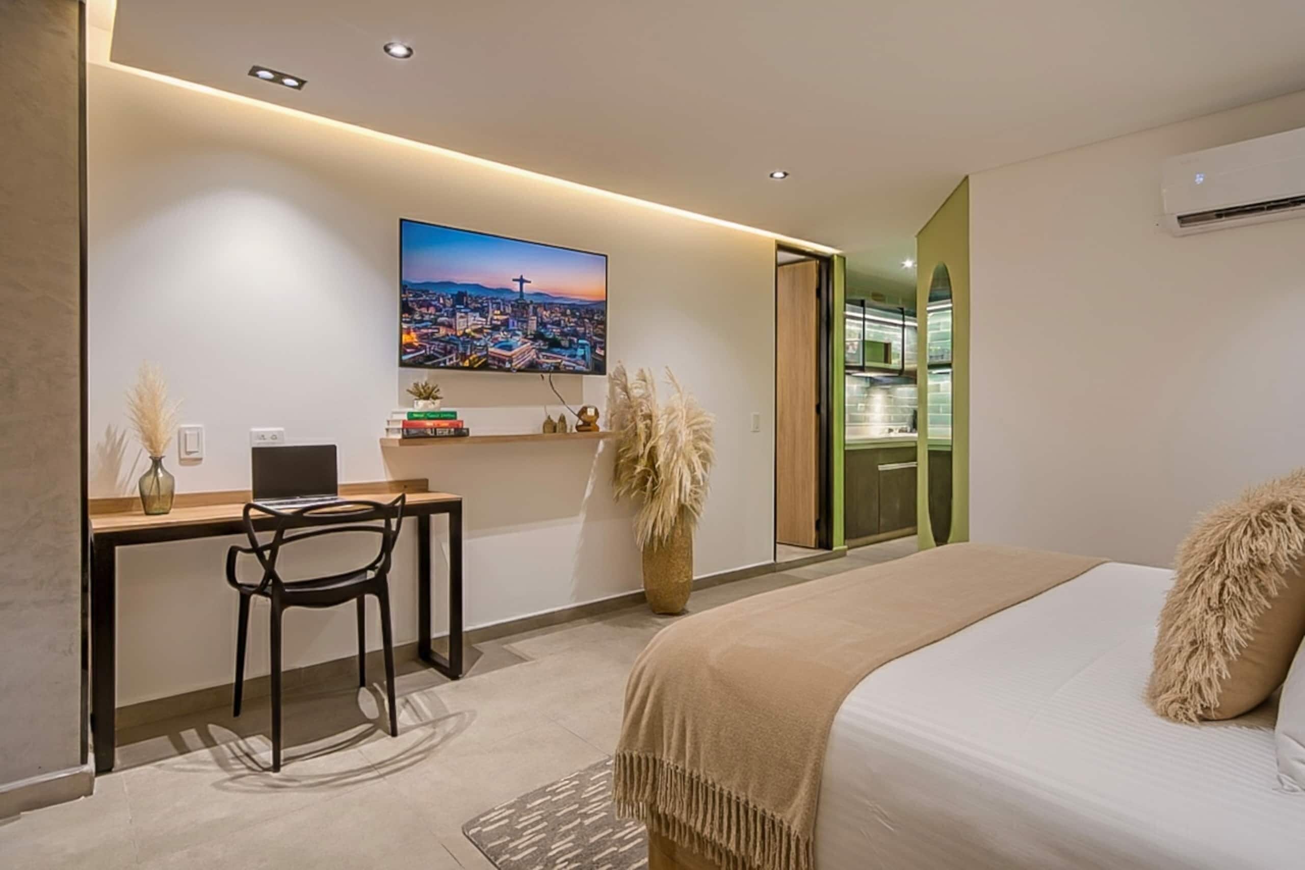 Una habitación de hotel moderna con una cama, un escritorio y un cuadro de paisaje urbano.