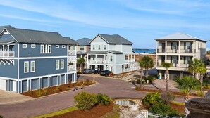A coastal residential area with multi-story houses, a paved driveway, and a sandy beach in the background. - Sea La Vie (Navarre)