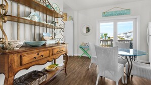 A dining area with a wooden buffet, wicker chairs, and a view of the sea. - Sea La Vie (Navarre)