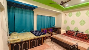 Quarto com duas camas, ventilador de teto e paredes com padrão.