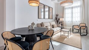 Un espace repas moderne avec une table ronde, des chaises noires et un canapé.