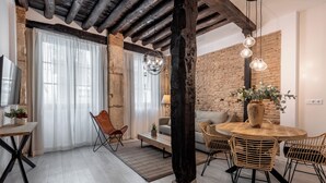 Un espace repas moderne avec une table en bois, des chaises en osier et un mur en briques.