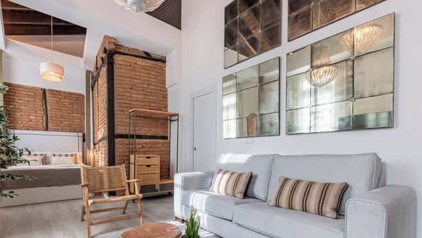 Un soggiorno moderno con un divano, un tavolino in legno e una parete decorata con mattoni.
