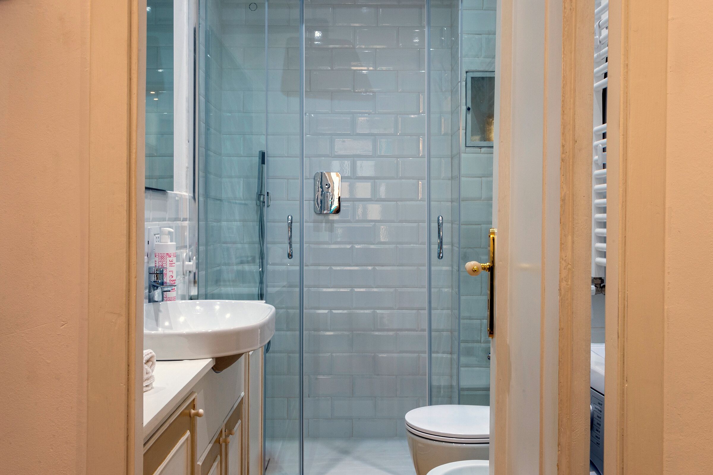 Ein modernes Badezimmer mit Duschkabine aus Glas, einem weißen Waschbecken und einer Toilette.