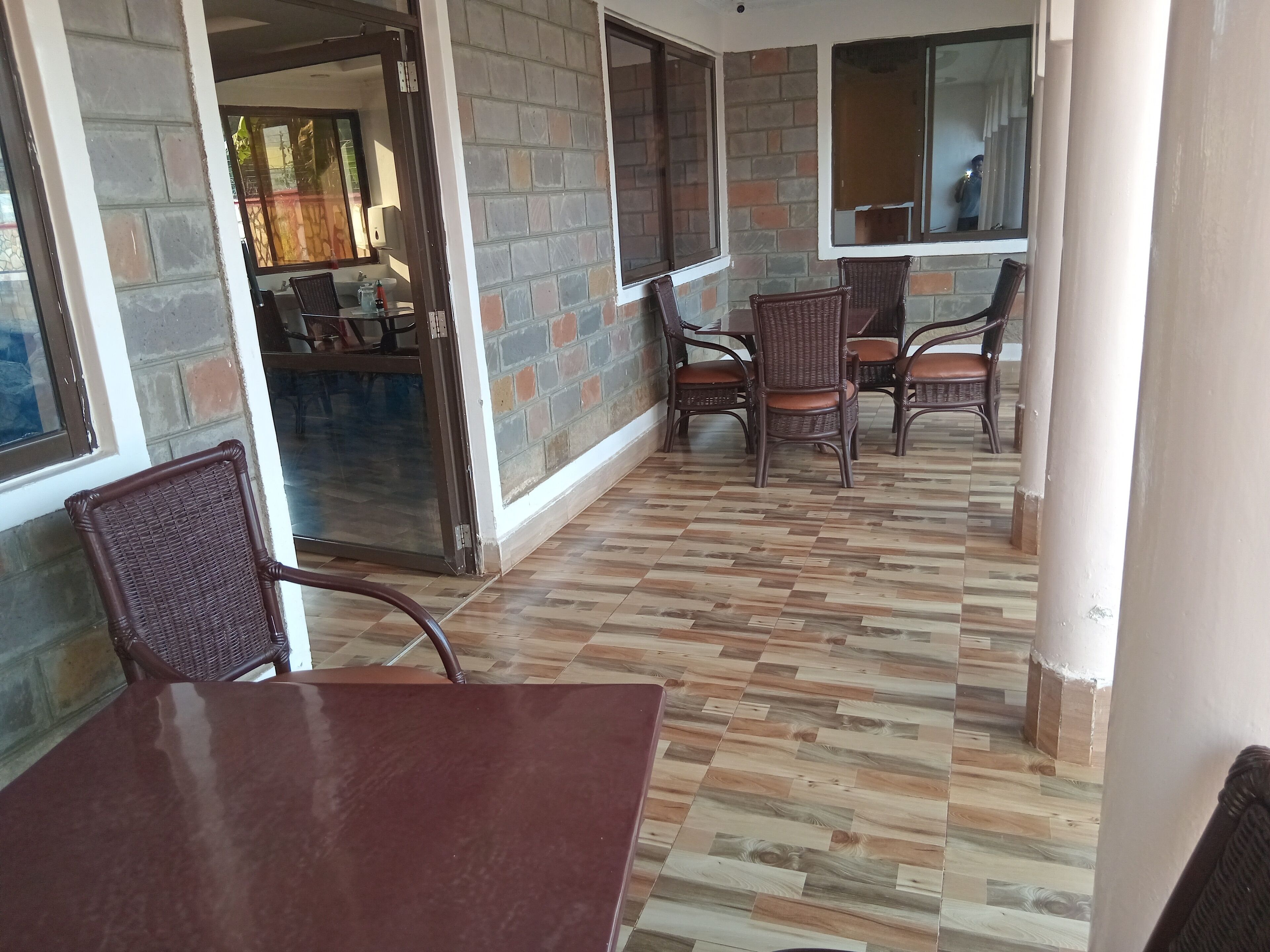 Et værelse med flisegulv, murstensvægge og fletmøbler.