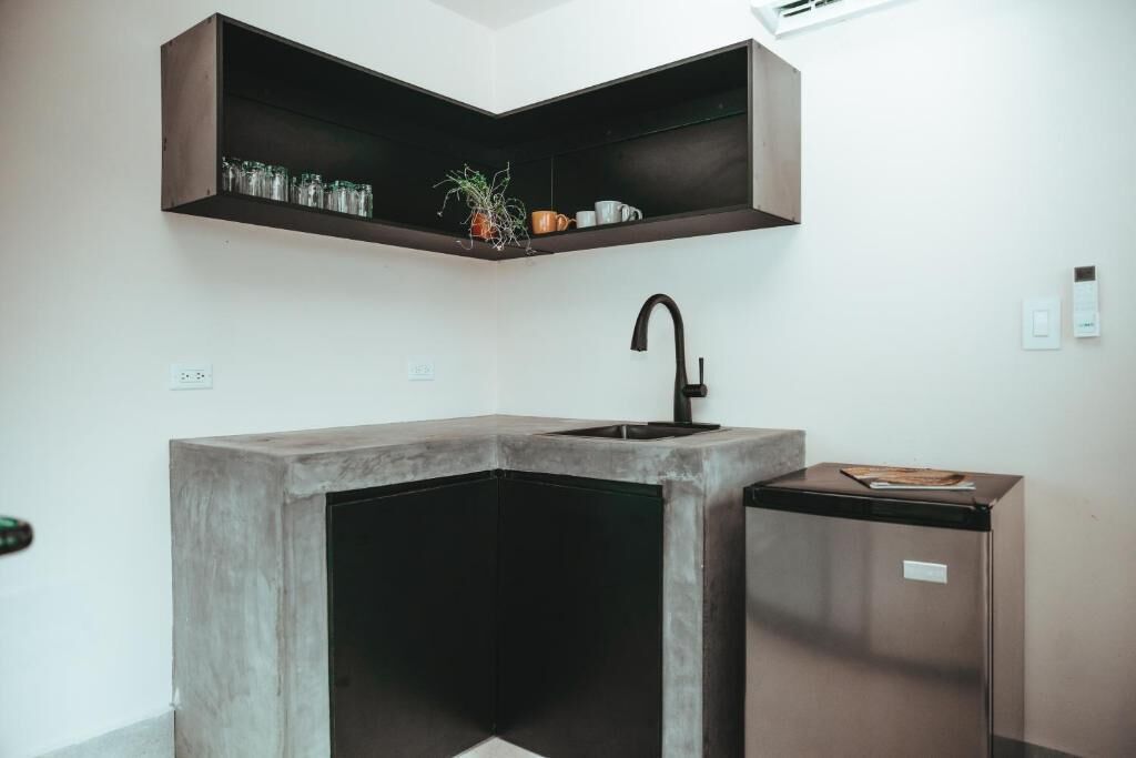 A modern kitchen with a built-in sink, a countertop, and a corner shelf above the sink.