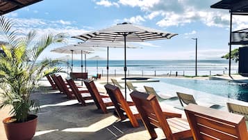 Una piscina al aire libre, sillones reclinables de piscina