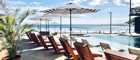 Una piscina al aire libre, sillones reclinables de piscina