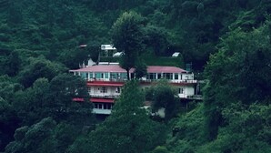 A multi-story building surrounded by dense forest. - The Perfect Hideout By Himalayan Grove (Dehradun)