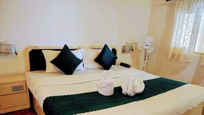 A neatly made bed with a green blanket, two pillows, and two towels folded on the bed. - The Perfect Hideout By Himalayan Grove (Dehradun)