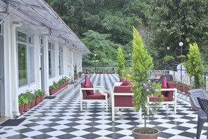 A checkered outdoor patio with seating and potted plants. - The Perfect Hideout By Himalayan Grove (Dehradun)