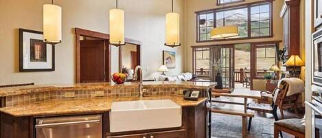 A spacious kitchen with a large island, wooden cabinets, and pendant lighting.