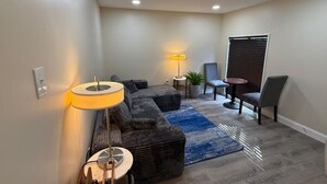 A modern living room with a sofa, chairs, a lamp, and a small table. - Near DC 5 bdrm 4.5 bth 11 beds 2 kitchens &parking (Silver Spring)