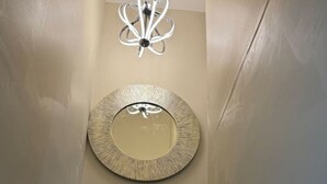 A staircase with a round mirror and a modern chandelier. - Near DC 5 bdrm 4.5 bth 11 beds 2 kitchens &parking (Silver Spring)