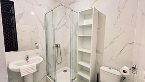 Ein Badezimmer mit Duschkabine, Waschbecken und Toilette.