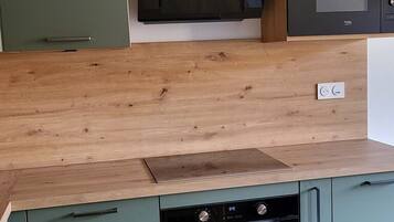 A kitchen with a microwave, oven, and wooden countertop.