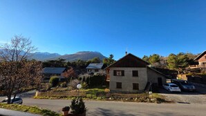 A residential area with houses, a street, and mountains in the background. - Charming apartment overlooking the valley (Briançon)