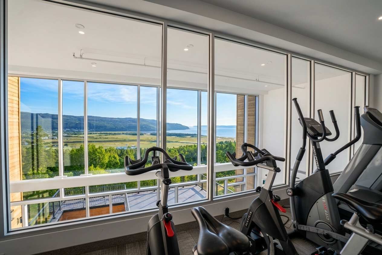 A gym with large windows overlooking a scenic landscape.